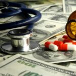 A stethoscope and pills are backgrounded by money to show savings from the payment integrity process