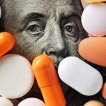 Prescription drugs sit atop a hundred-dollar bill to show savings from using examples of cost containment in healthcare