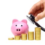 A doctor holds a stethoscope to a piggy bank behind stacks of coins to show potential savings from understanding pros and cons of managed care